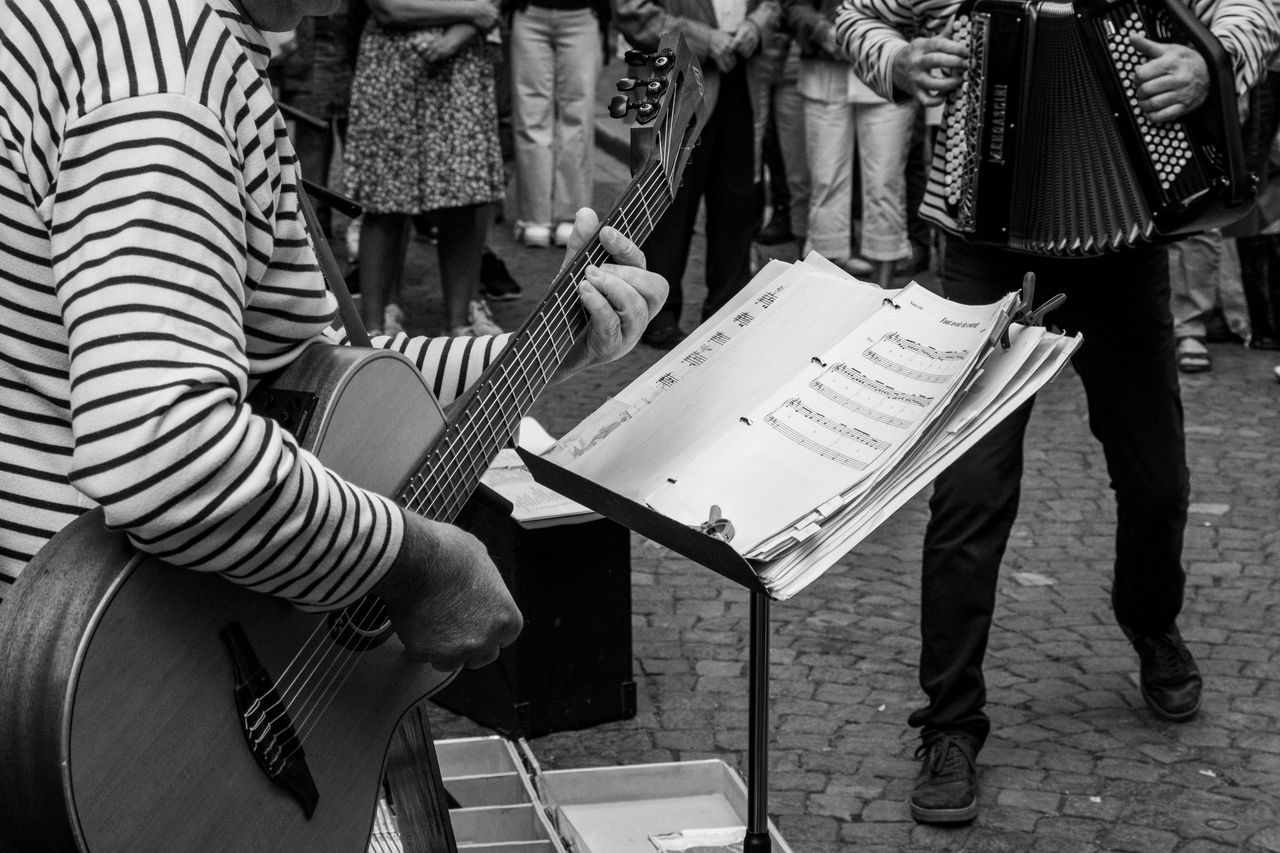 Black and white photo of street musicians performing with guitar and accordion in St. Malo, France.